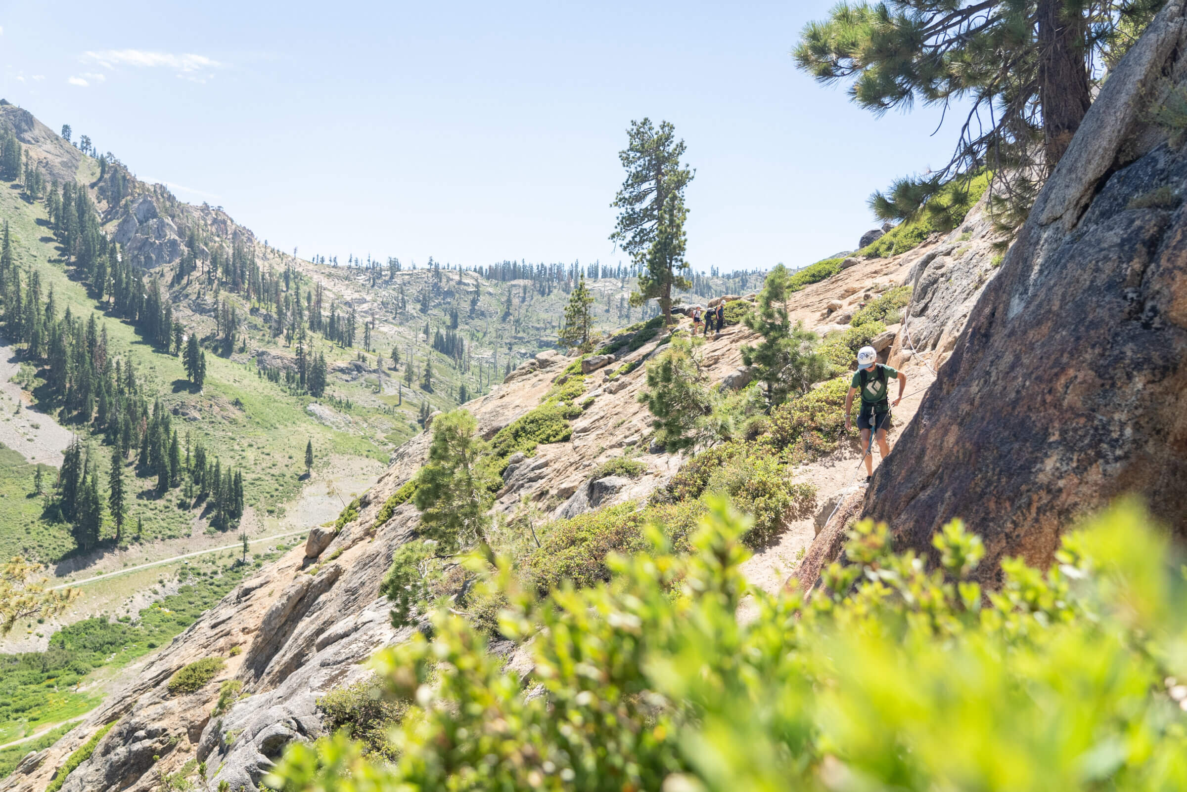 A climber on a traverse climbing the Tahoe Via Ferrata during the summer. One of the best Lake Tahoe adventures!