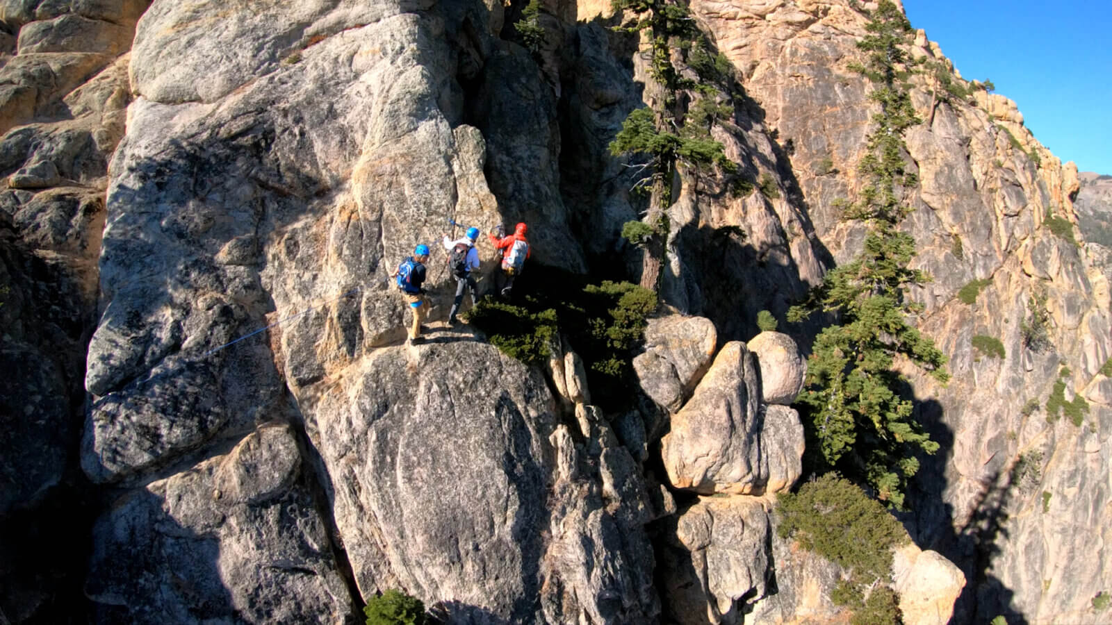 A group of climbers standing on the Tahoe Via Ferrata above Palisades Tahoe Village in Olympic Valley, CA. One of the best Lake Tahoe adventures!
