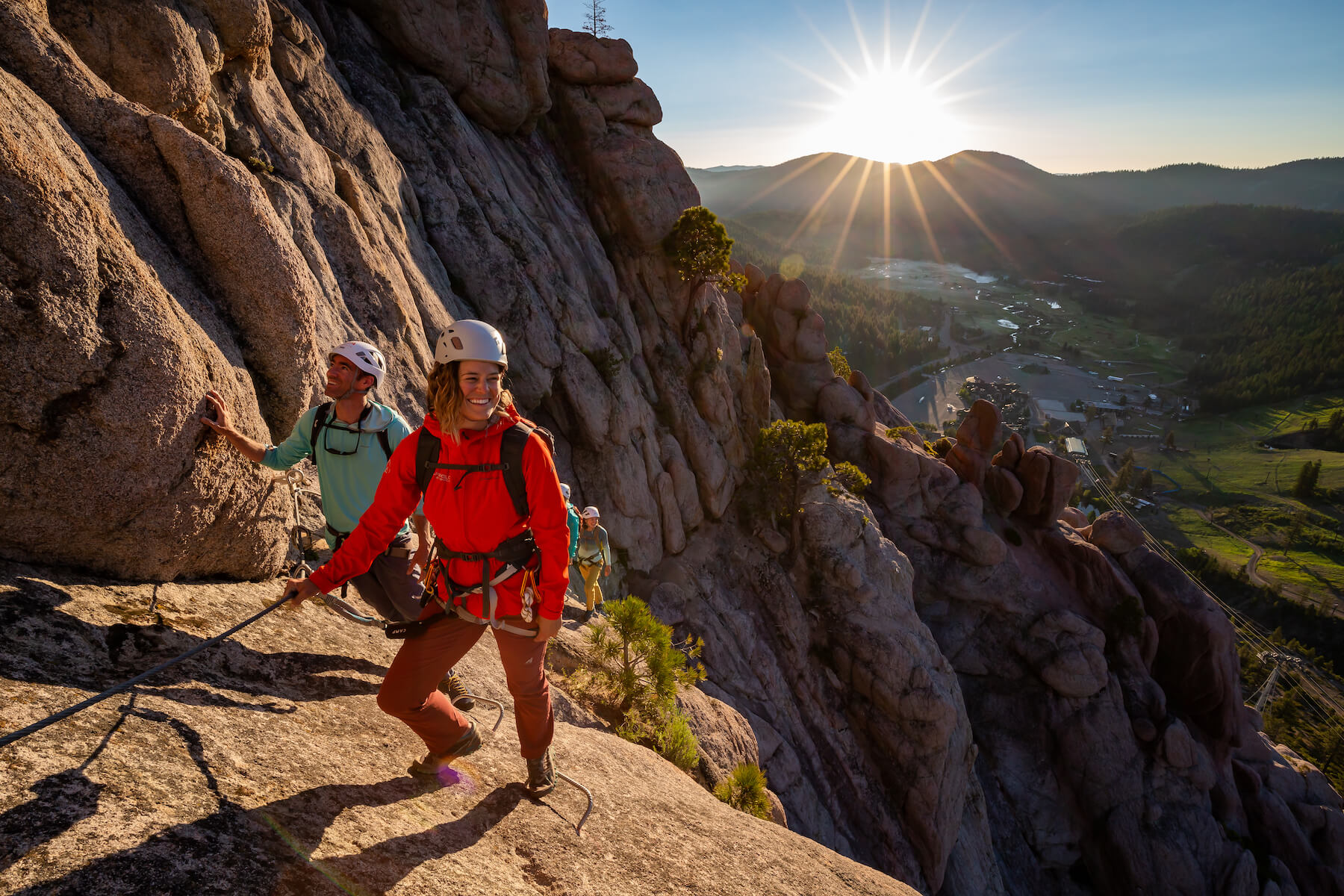 A group of climbers on the Tahoe Via Ferrata at Palisades Tahoe during sunrise. One of the best Lake Tahoe adventures!