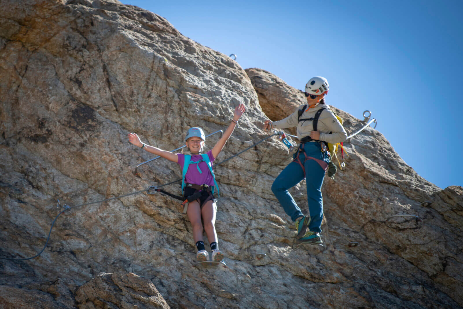 A young climber and a guide climbing the Tahoe Via Ferrata at Palisades Tahoe in Olympic Valley. One of the best Lake Tahoe adventures!