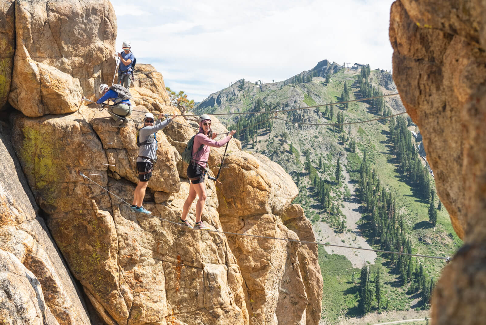 A group of climbers on a monkey bridge on the Tahoe Via Ferrata at Palisades Tahoe in Olympic Valley. One of the best Lake Tahoe adventures!