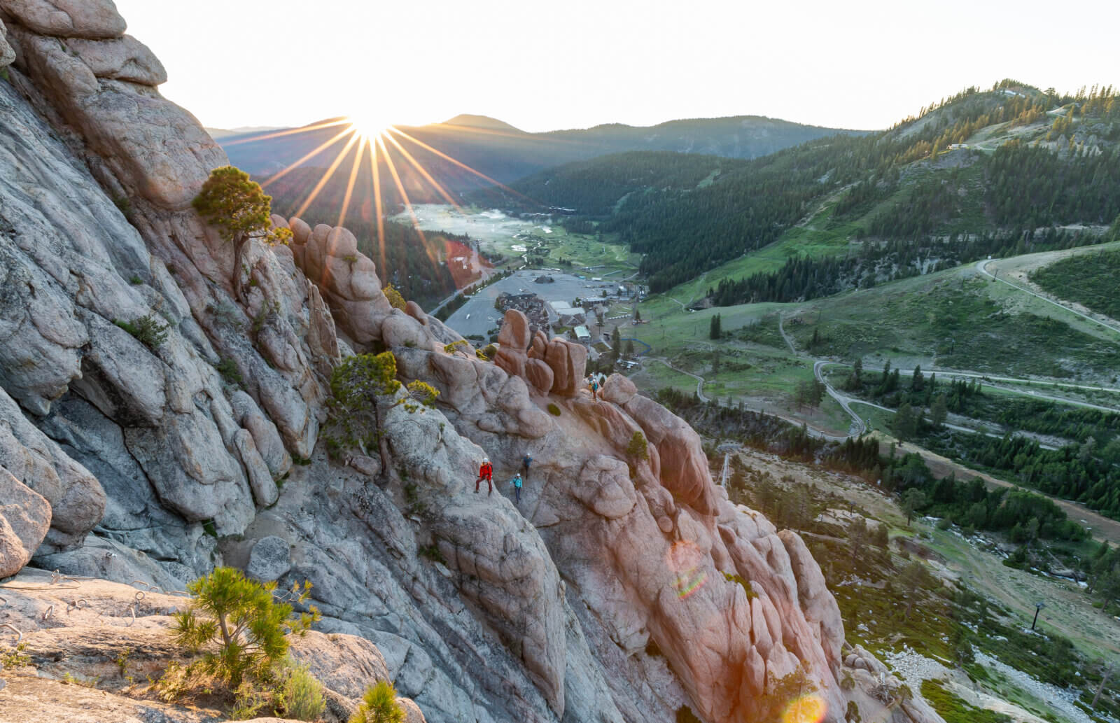A group of climbers on the Tahoe Via Ferrata at Palisades Tahoe during sunrise. One of the best Lake Tahoe adventures!