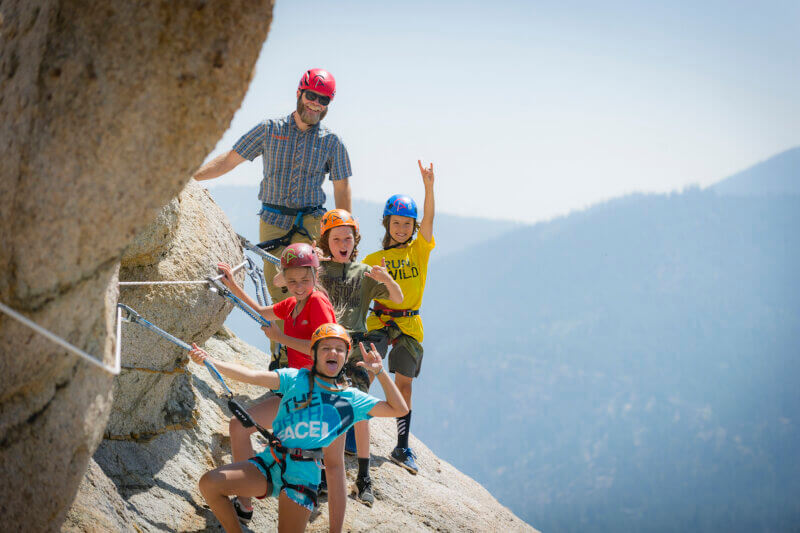 A group of kids on the Tahoe Via Ferrata with their certified rock guide from Alpenglow Expeditions.